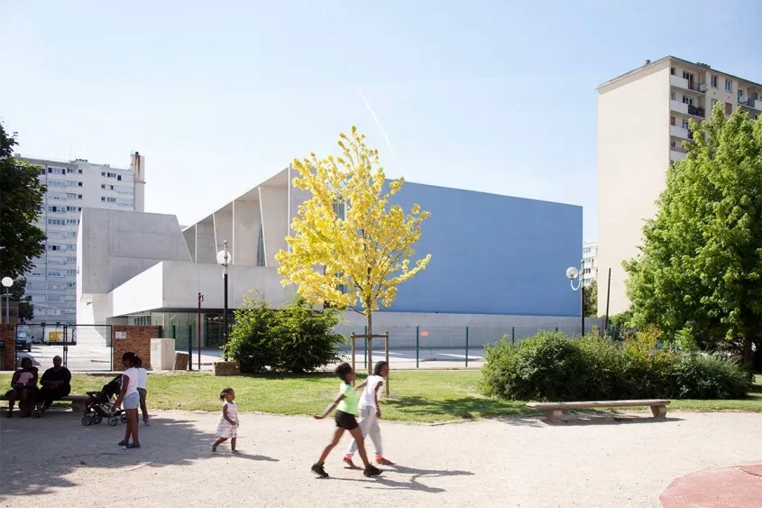 l’extension est en béton gris clair. son grand portique fonctionne comme un brise-soleil géant.