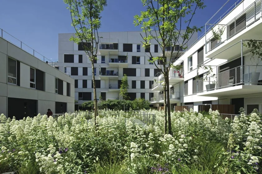 Côté cœur d’îlot, les accès aux logements sont dissociés de la rue et placés au premier niveau. Aménagé en jardins largement plantés, l’espace est particulièrement qualitatif.