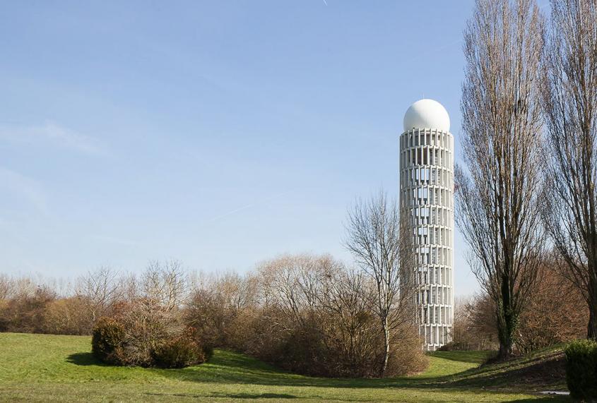 Haut de 57 m, le fût cylindrique de la tour radar se compose de 308 claires- voies ouvrant en partie basse sur le paysage et en partie haute sur le ciel et ses variations.