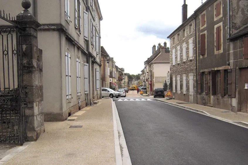 Au premier plan, la route de Beaune avec ses trottoirs en béton désactivé. Au second plan, la rue de la République en béton désactivé coloré sur chaussée et en béton bouchardé sur les parkings.