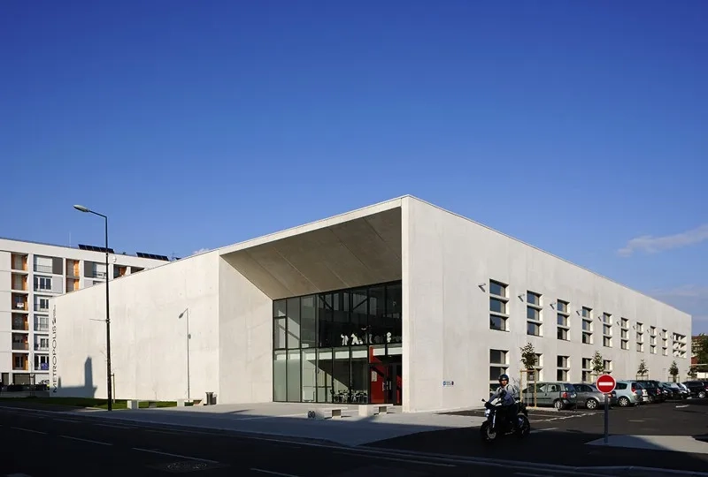 Une architecture sobre et élégante percée d’ouvertures dont le dessin fait écho aux barres de logement voisines.