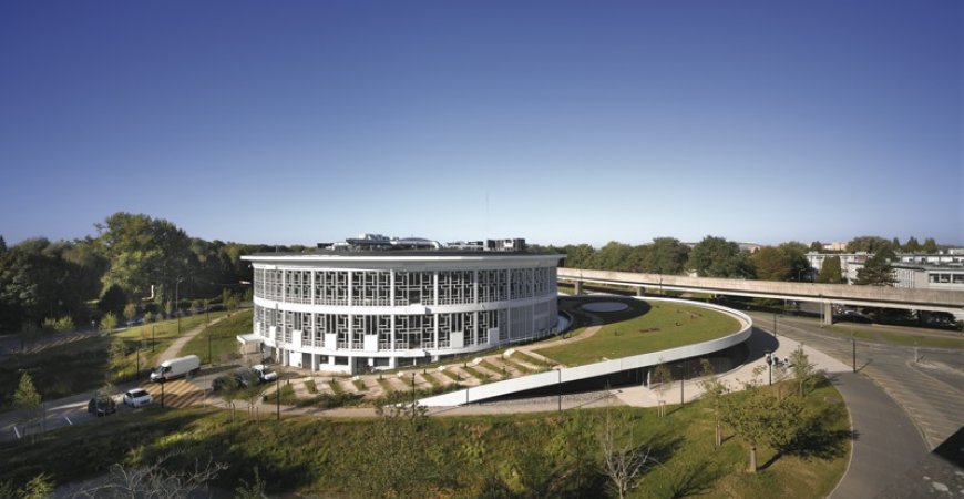La toiture végétalisée de l’extension, directement accessible depuis le sol, devient une prolongation des espaces verts du campus.