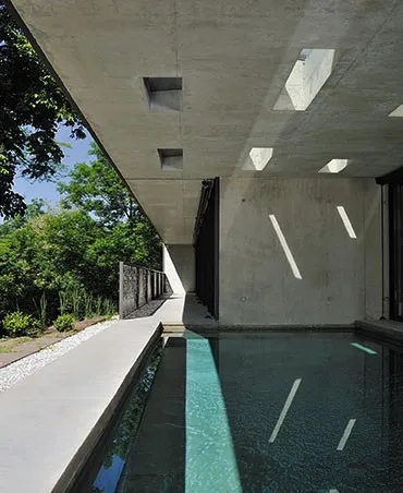 Tout en étant extérieure, la piscine est inscrite dans le volume de la maison. Tout en étant extérieure, la piscine est inscrite dans le volume de la maison.
