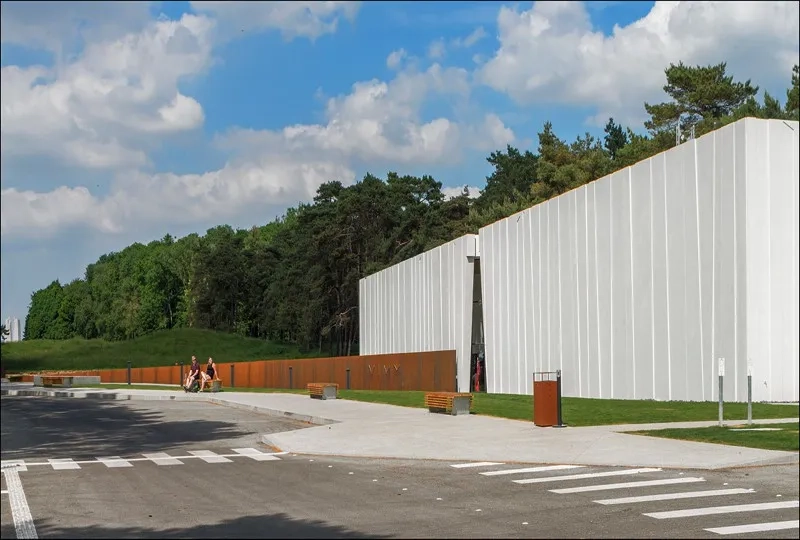 Le mémorial, installé sur la crête, et le volume du centre d’accueil s’alignent pour former l’axe de mémoire. Le mémorial, installé sur la crête, et le volume du centre d’accueil s’alignent pour former l’axe de mémoire.Le mémorial, installé sur la crête, et le volume du centre d’accueil s’alignent pour former l’axe de mémoire.