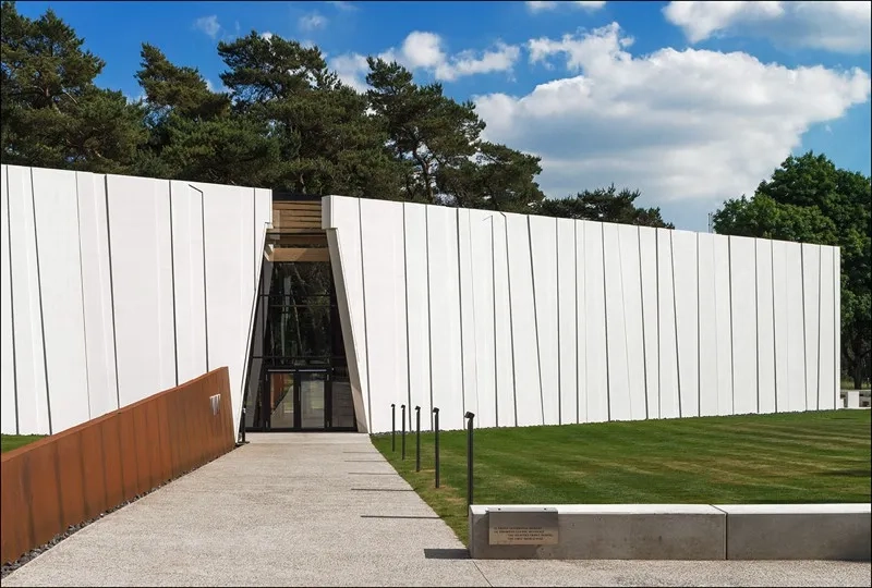 Le second axe, axe de l’histoire, est symbolisé par une lame en acier corten qui guide le visiteur vers l’entrée. Le second axe, axe de l’histoire, est symbolisé par une lame en acier corten qui guide le visiteur vers l’entrée.