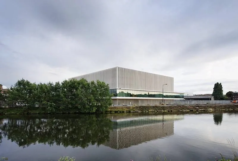 Façade nord sur le canal. Le choix de matériaux pérennes et le soin de leur mise en œuvre participent de l’image du palais. entre les fines colonnes de béton, la double peau vitrée assure un tampon thermique. Façade nord sur le canal. Le choix de matériaux pérennes et le soin de leur mise en œuvre participent de l’image du palais. entre les fines colonnes de béton, la double peau vitrée assure un tampon thermique.