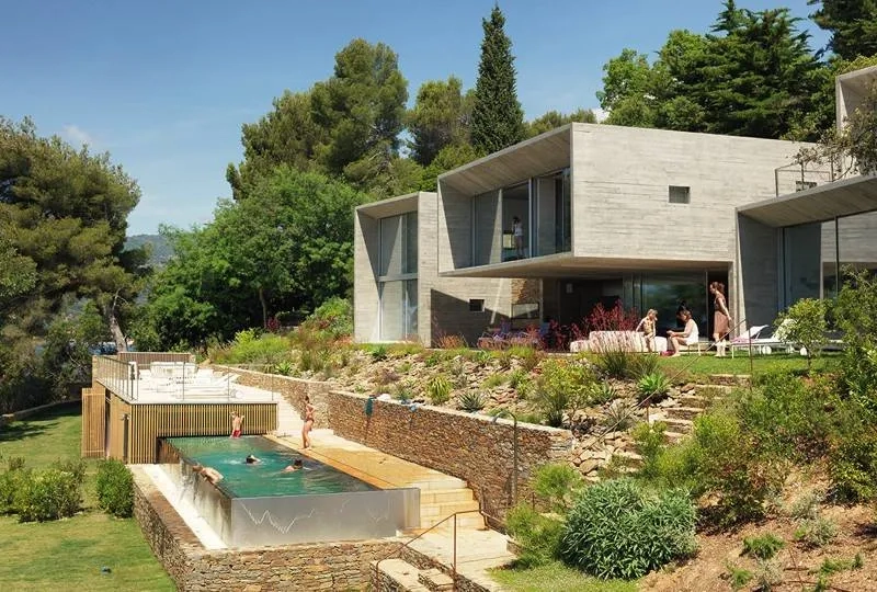 Le béton brut, le verre et la pierre sèche dialoguent avec la végétation luxuriante de la riviera. Le béton brut, le verre et la pierre sèche dialoguent avec la végétation luxuriante de la riviera.