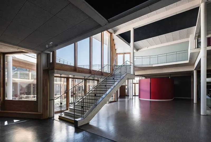 Hall d’accueil éclairé par de grandes baies vitrées donnant sur le patio. l’escalier en béton est suspendu dans la double hauteur. Hall d’accueil éclairé par de grandes baies vitrées donnant sur le patio. l’escalier en béton est suspendu dans la double hauteur.