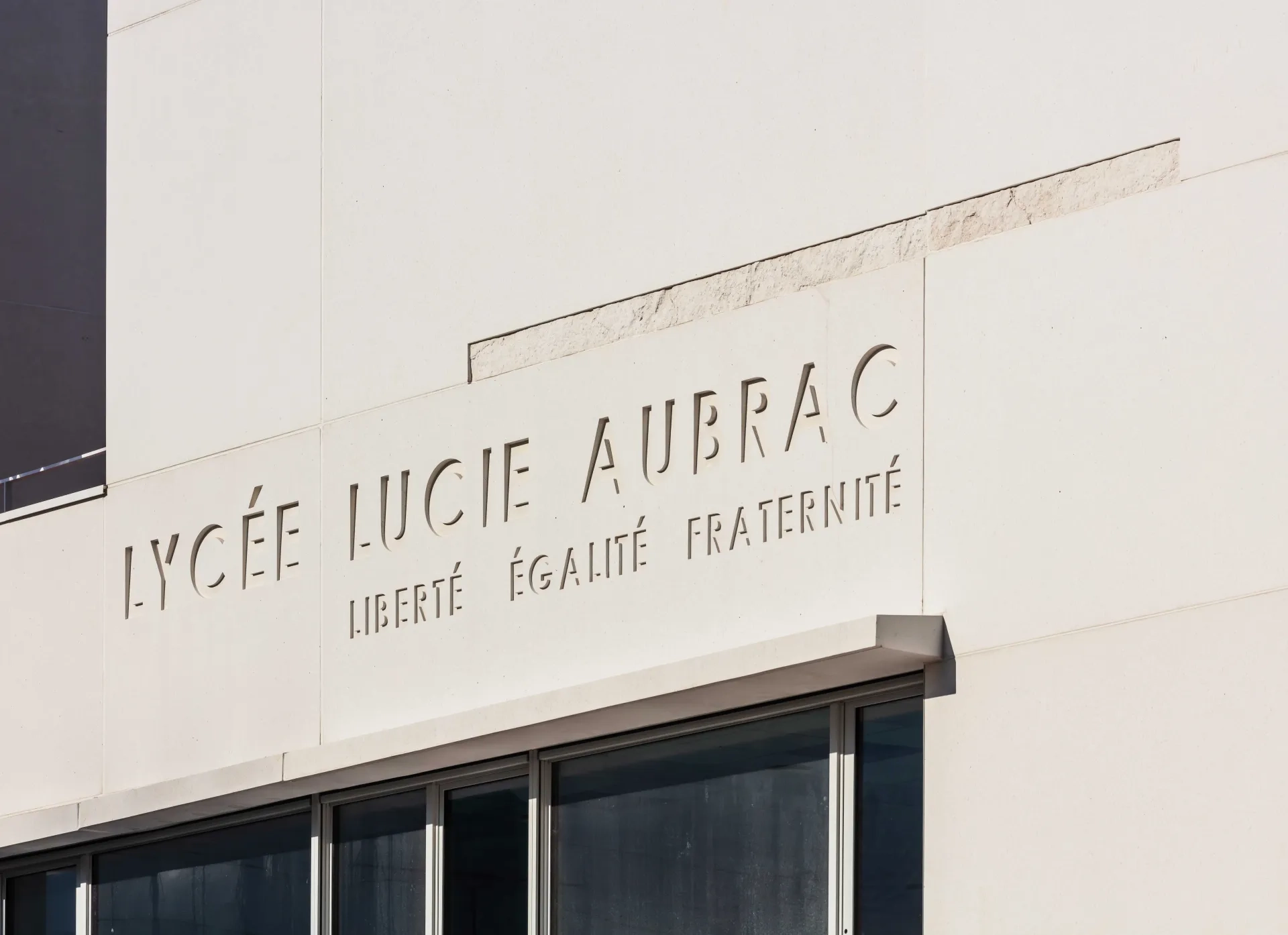 Détail d’un insert de béton matricé et de la signalétique incrustés dans le béton poli. 