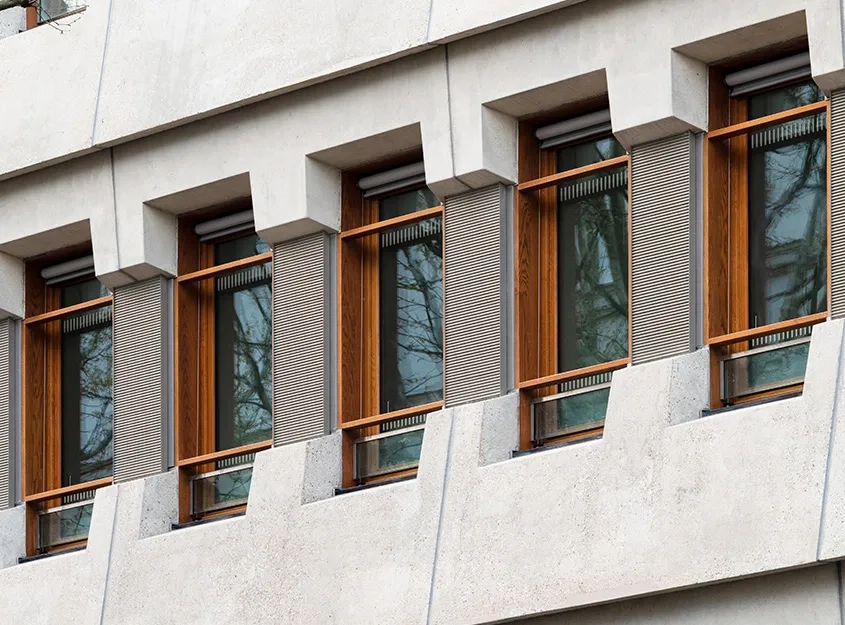 Le béton brut et les menuiseries donnent une apparence domestique aux façades rénovées, dont le dessin est conservé. Le béton brut et les menuiseries donnent une apparence domestique aux façades rénovées, dont le dessin est conservé.