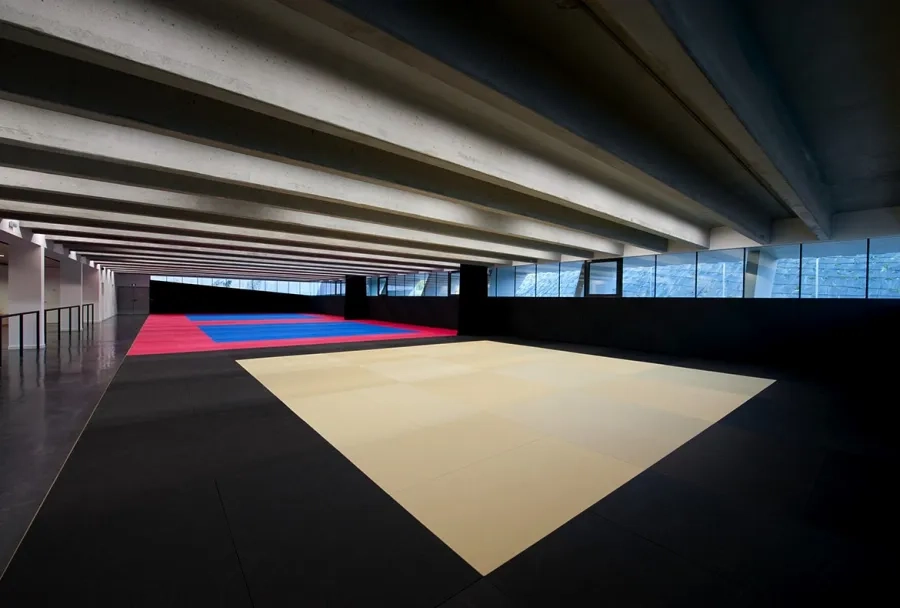 la puissance des poutres structurelles en béton de grande portée signe l’écriture architecturale du dojo. la puissance des poutres structurelles en béton de grande portée signe l’écriture architecturale du dojo.