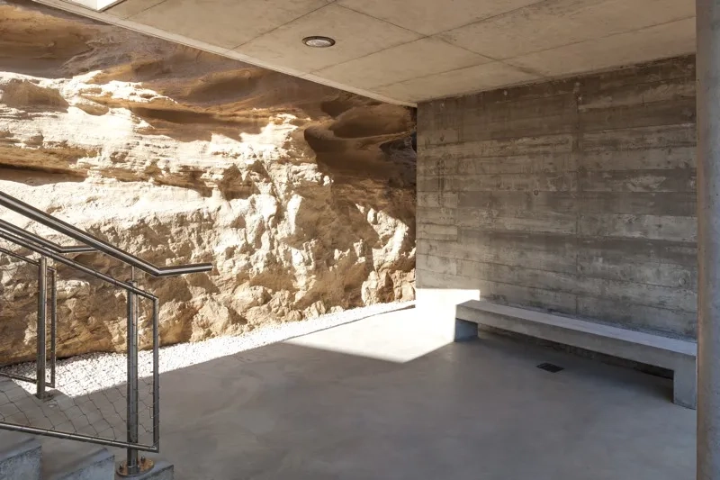 Les empreintes rythmant le parement du béton brut tissent des liens avec les strates calcaires de la falaise. Les empreintes rythmant le parement du béton brut tissent des liens avec les strates calcaires de la falaise.