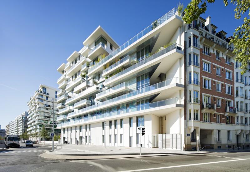sur l’avenue Lefaucheux, les balcons  filants en béton blanc accompagnent l’étirement horizontal du bâtiment.