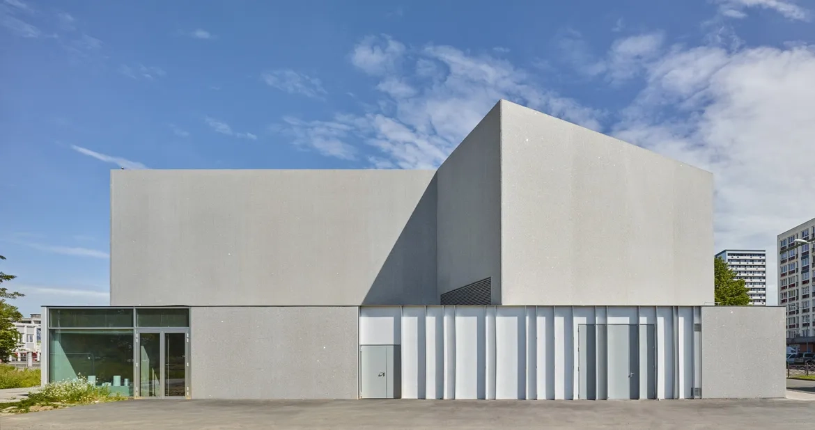 L’enveloppe du bâtiment est rythmée par les grands plans vitrés et les parois verticales en béton gris poli ou bouchardé. des éclats de miroir sont incorporés au béton. ils scintillent sous le soleil et animent les façades de façon changeante et inattendue.