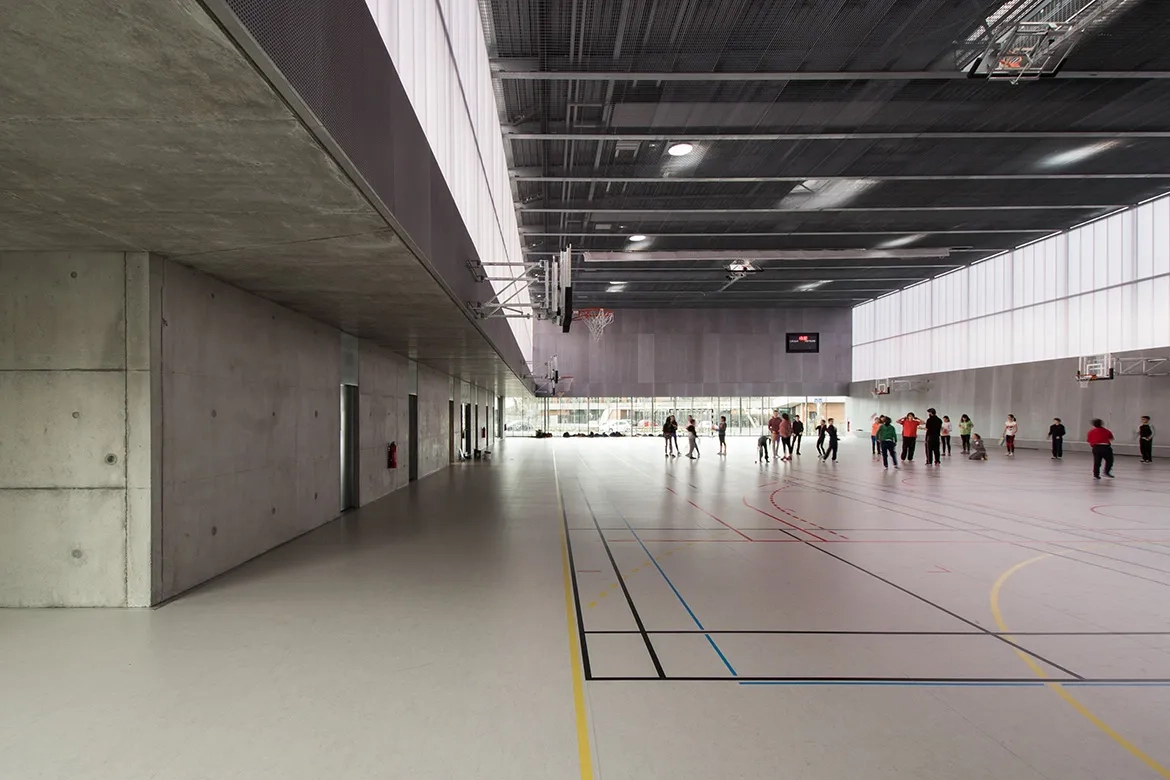 Vue sur la salle multisport baignée de lumière naturelle.