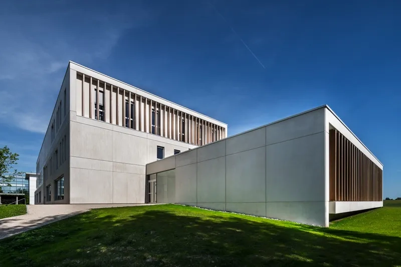 L’ensemble de l’enveloppe du bâtiment est réalisé avec des éléments préfabriqués en béton de type mur à co rage et isolation intégrés au parement lisse ou texturé et dont la couleur beige rappelle la tonalité de la pierre locale. L’ensemble de l’enveloppe du bâtiment est réalisé avec des éléments préfabriqués en béton de type mur à co rage et isolation intégrés au parement lisse ou texturé et dont la couleur beige rappelle la tonalité de la pierre locale.