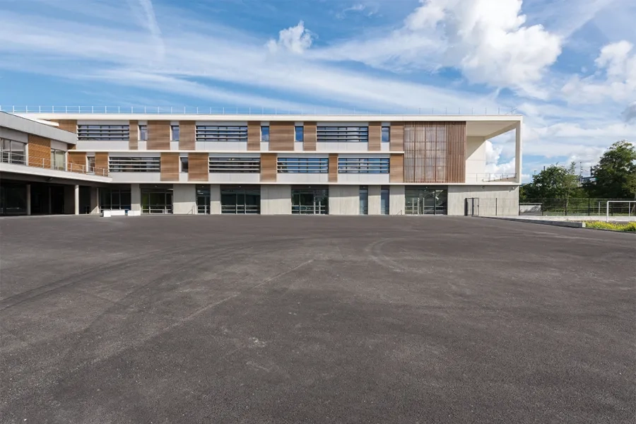 Peintes ou revêtues de bois ligné, les façades courantes s’inscrivent entre des éléments horizontaux en béton blanc.