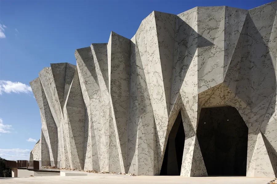 du nord au sud, le bâtiment passe du lisse du béton préfabriqué à la rugosité du béton projeté et soufflé.