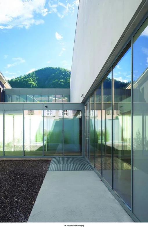un patio intérieur planté sépare le bâtiment existant de la nouvelle extension.