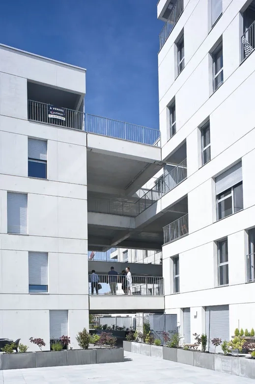 Une trame de joints creux unifie les masses bâties en béton blanc autoplaçant. Une trame de joints creux unifie les masses bâties en béton blanc autoplaçant.