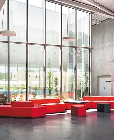 Le hall et la paroi de béton qui délimite le volume de la salle.