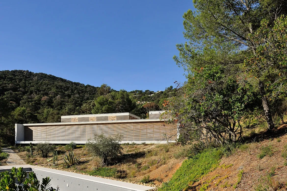 Des persiennes coulissantes et entièrement escamotables permettent de se protéger du soleil et de fermer entièrement la maison.