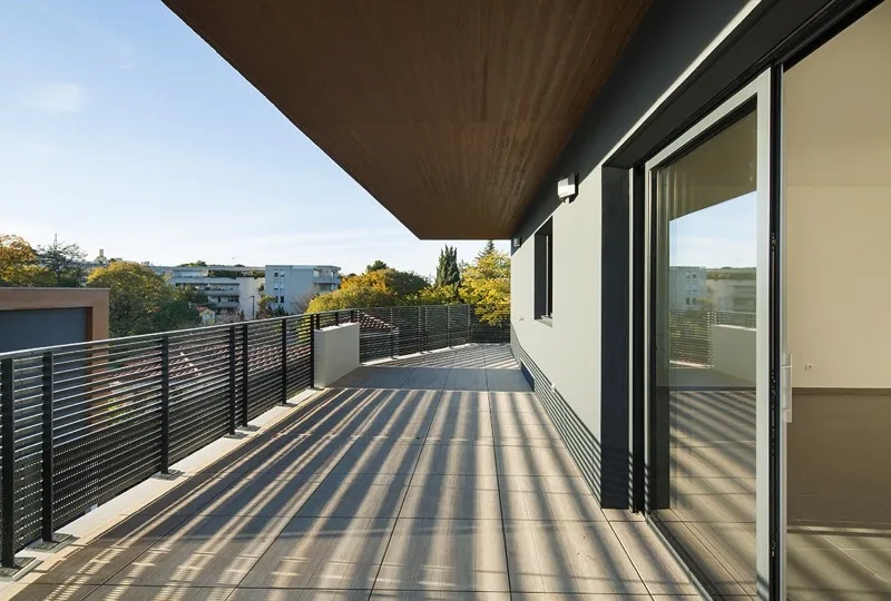 Vaste terrasse partiellement protégée par le porte-à-faux de l’attique qui fait brise-soleil. la matrice du béton et sa lasure brune s’accordent aux pins parasols. Vaste terrasse partiellement protégée par le porte-à-faux de l’attique qui fait brise-soleil. la matrice du béton et sa lasure brune s’accordent aux pins parasols.