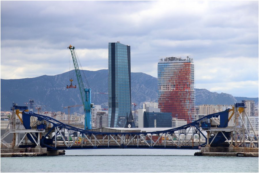 Depuis la mer, la façade nord rougeoyante de la Marseillaise émerge à côté de la tour CMA CGM : symboles d’un renouveau économique annoncé.