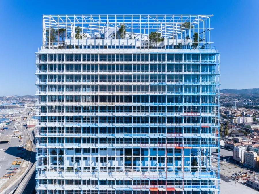 Façade sud.Par leur prolongement sur les faux plafonds, les couleurs des brise-soleil estompent la limite entre intérieur et extérieur. Façade sud.Par leur prolongement sur les faux plafonds, les couleurs des brise-soleil estompent la limite entre intérieur et extérieur.
