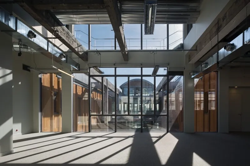 Au cœur de l’édifice, un patio triple hauteur, créé par la suppression de 4 000 m2 de planchers, assure une réponse environnementale en termes de ventilation, de rafraîchissement, de désenfumage et de lumière naturelle. Au cœur de l’édifice, un patio triple hauteur, créé par la suppression de 4 000 m2 de planchers, assure une réponse environnementale en termes de ventilation, de rafraîchissement, de désenfumage et de lumière naturelle.