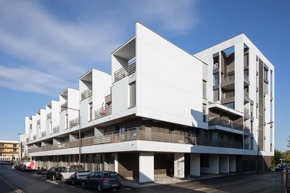 Les façades en béton lasuré sont réalisées grâce à des murs à coffrage intégré de qualité architec- tonique, combinés avec des éléments d’angle et des potelets en béton préfabriqué. 