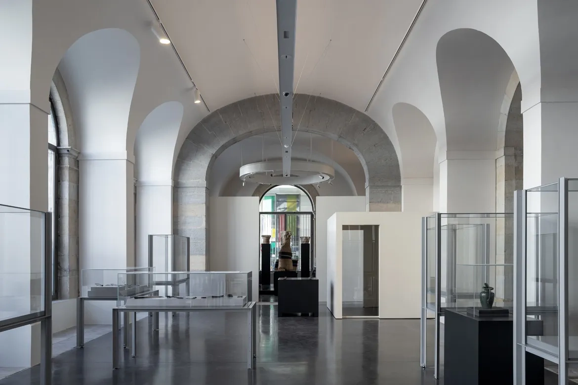 vue sur une salle d’archéologie. La présence de la lumière naturelle et les matériaux mis en œuvre, comme le béton ciré au sol, caractérisent l’ambiance des lieux.