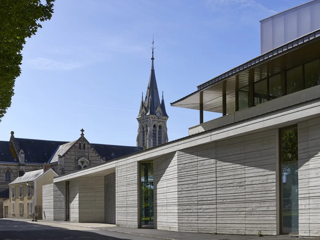 Aux côtés de l’église, le béton instaure un dialogue des matières avec l’existant. aux côtés de l’église, le béton instaure un dialogue des matières avec l’existant.