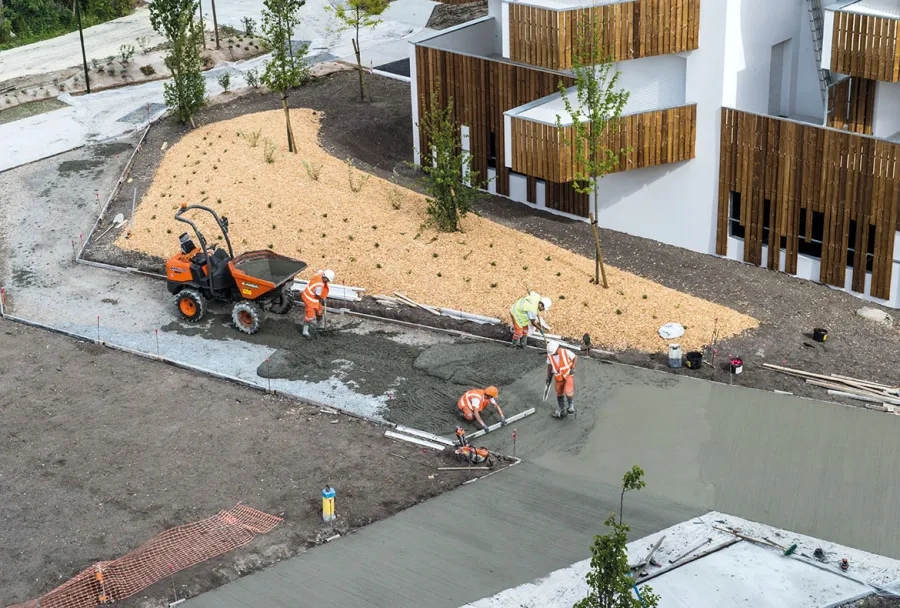Acheminé sur le chantier par dumper, le béton a d'abord été tiré à la règle. Acheminé sur le chantier par dumper, le béton a d'abord été tiré à la règle.