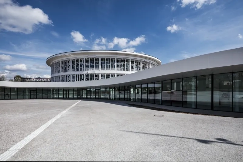 La façade largement vitrée de l’extension rend visible de l’extérieur ce qui se passe dans le bâtiment et invite à entrer. La façade largement vitrée de l’extension rend visible de l’extérieur ce qui se passe dans le bâtiment et invite à entrer.