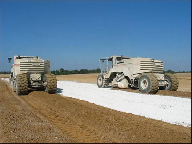Traitement des sols - Un malaxeur mélange le liant hydraulique routier avec le sol