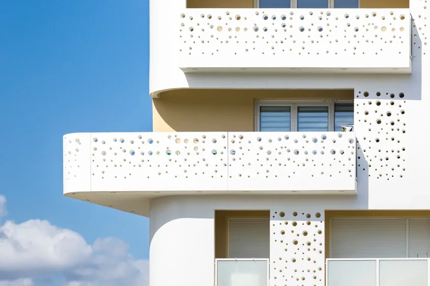 Des panneaux préfabriqués en béton perforés de trous de différents diamètres viennent au niveau des balcons et des loggias. Ils jouent un rôle de filtre et préservent l’intimité des logements.