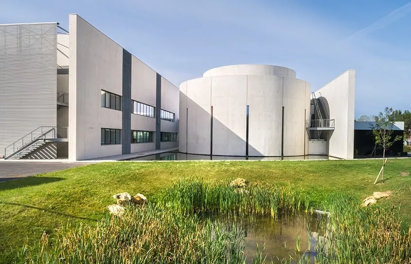 Les voiles courbes du hall et de l’auditorium, ainsi que les façades des laboratoires sont en béton autoplaçant blanc.