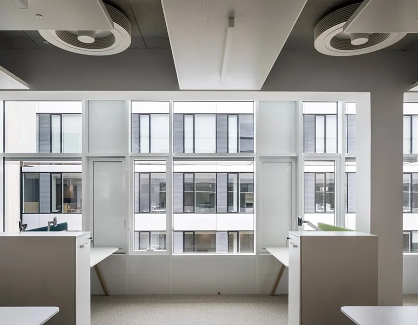 Les plateaux en open space et les grilles de ventilation en façades permettent en été de faire circuler l’air frais dans les bureaux pendant la nuit. Grâce à l’inertie du béton, les frigories stockées sont restituées en journée.