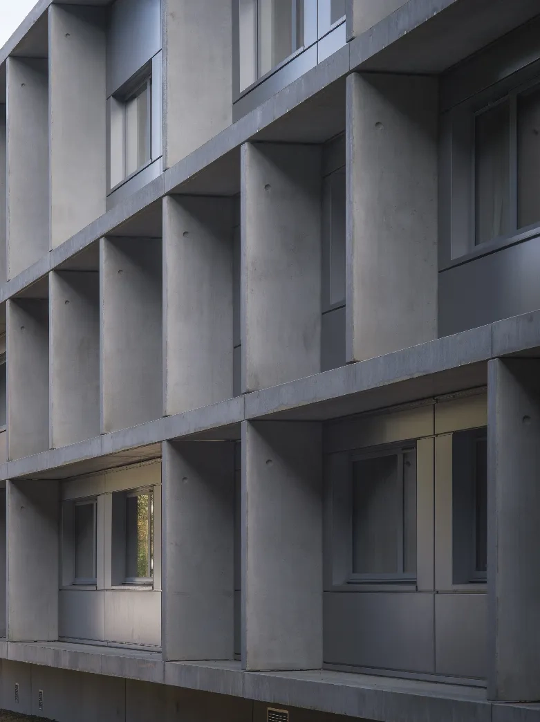 La résille orthogonale sur les façades des chambres est constituée d’éléments préfabriqués en béton recouverts d’une lasure grise.