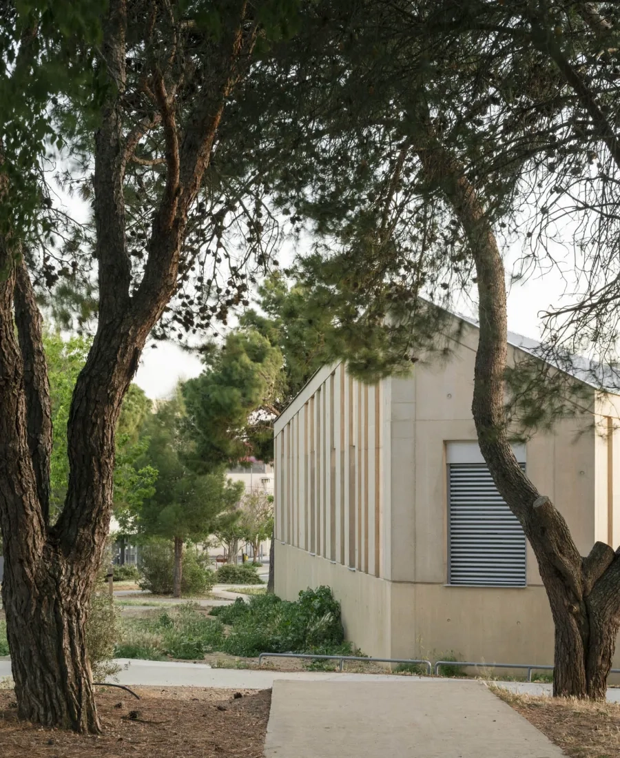 La façade extérieure joue un rôle de « gangue » protectrice. La teinte calcaire du béton résonne avec les teintes naturelles et chaleureuses du site.