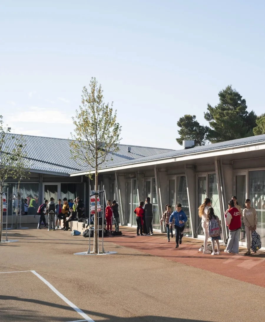 Protégée par l’organisation du bâti, la cour devient le prolongement physique des salles de classe.