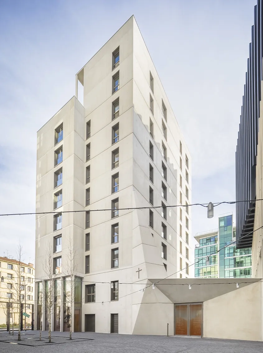 Nichée entre la résidence sociale et le bâtiment de bureaux, la chapelle est accessible par la venelle qui devient parvis.