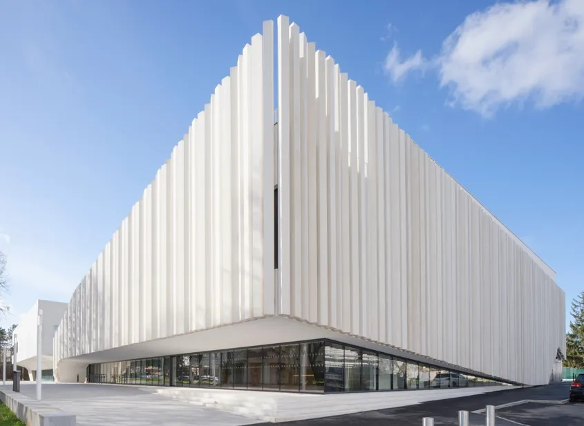 Maison des services publics Gisèle-Halimi – Elle se distingue du gymnase par son voile de façade, celui-ci se soulève pour accompagner l’entrée dans les lieux.