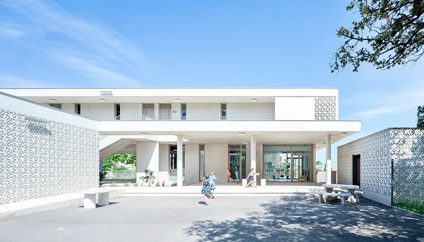 Le béton des façades et du sol semble couler dans le terrain et délimiter le jardin.
