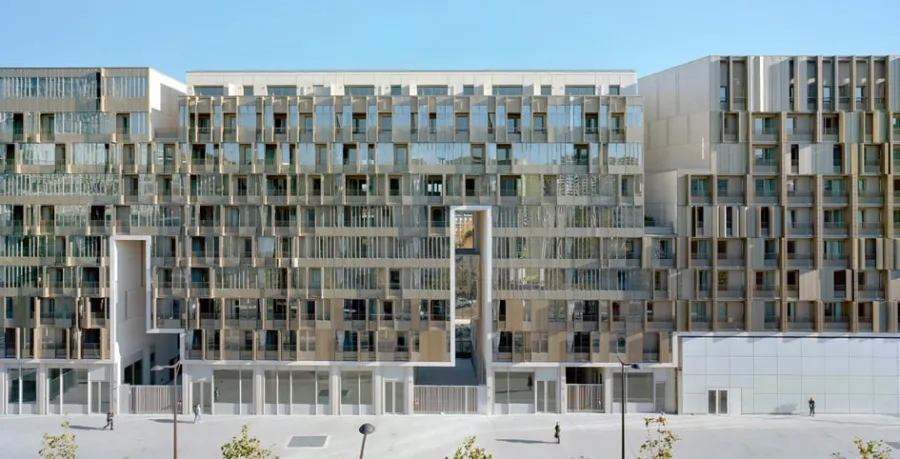Animée par le jeu toujours changeant des volets mobiles, la façade principale sur l’avenue est rythmée par les porches traversants lumineux et les failles longilignes.