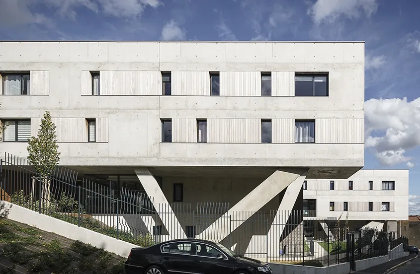 Le soulèvement d’une partie de la barrette de logements par des poteaux obliques allège la masse bâtie.
