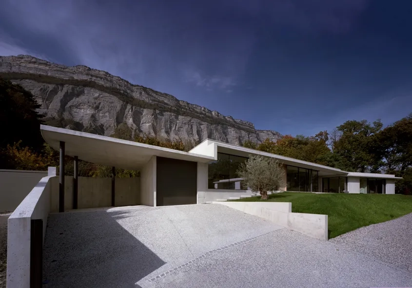 Dès l'entrée, la maison séduit par ses lignes tendues et la variété des surfaces en béton.