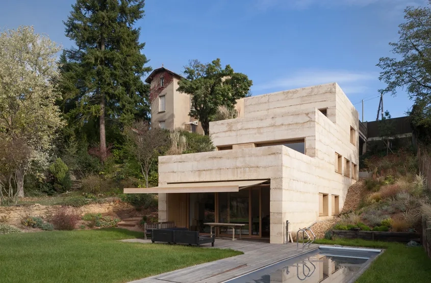 Le propriétaire de la Maison P possédait, à Saint-Cyr-au-Mont-d’Or, une demeure bourgeoise datant de la fin du XIXe siècle. Souhaitant changer de cadre de vie, il a fait construire, juste à côté de son ancienne habitation, une villa contemporaine.