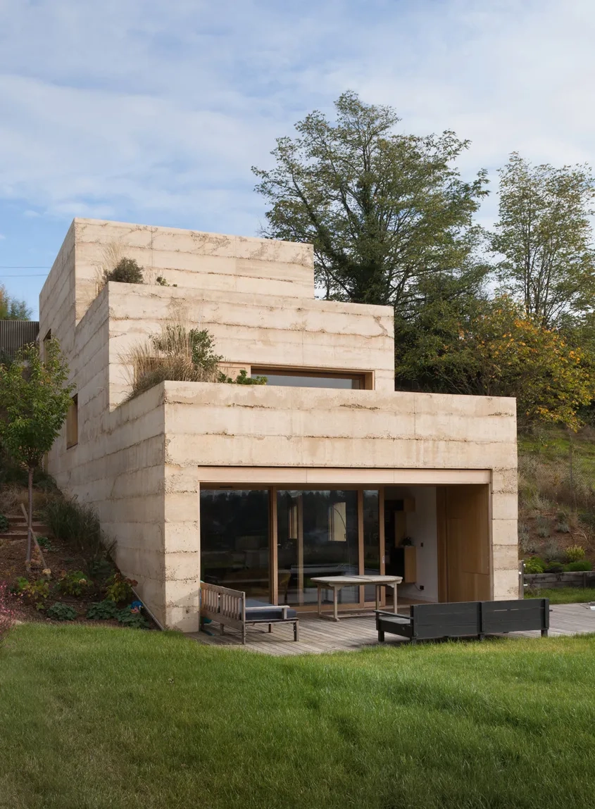 Les avancées successives dessinent trois blocs décalés qui sculptent le volume et fabriquent deux terrasses offertes aux espaces intérieurs. La texture et la couleur ocre clair du béton des façades béton rappellent la pierre dorée du Beaujolais que l’on retrouve dans la construction locale.